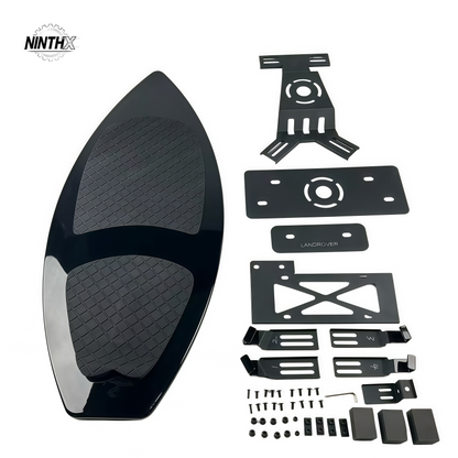 Gloss black surfboard-style spare tire delete panel with textured EVA deck pad and full mounting bracket kit for Land Rover Defender L663