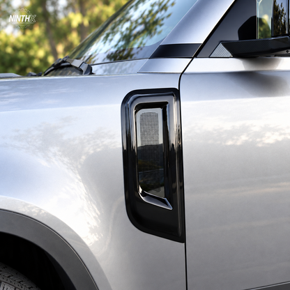 Gloss black fender air intake bug screen cover fitted to the side vent of a Defender L663.