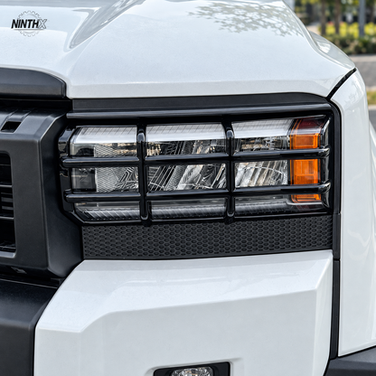 Gloss black headlight guard installed on the front lamp of a white Toyota Land Cruiser Prado LC250.